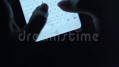 双手在智能手机特写上键入文本。 晚上用智能手机关门。